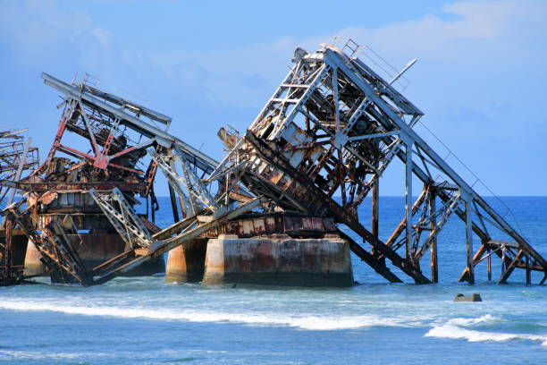 Aiwo, Nauru island: ruins of Cantilever 1 -  Nauru Phosphate Cantilevers, massive steel cantilevers erected to load phosphate directly on large ships moored just off the reef, as there was no dock - Discovered around 1900 and exploited from 1906, phosphate deposits were crucial for the country's economy. Trading Harbour of Nauru - industrial architecture.