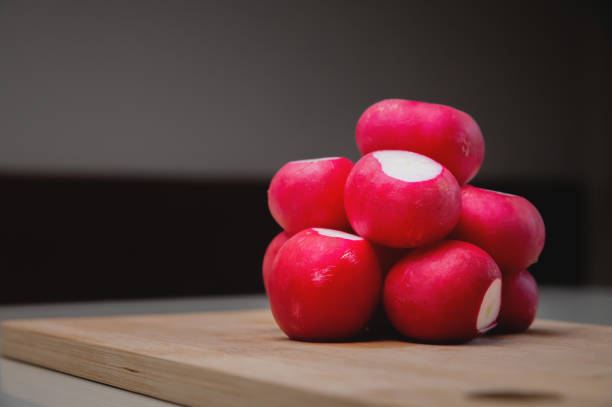 de cerca, el rábano fresco y jugoso yace en un tobogán sobre una tabla de madera. banner publicitario - radish fotografías e imágenes de stock