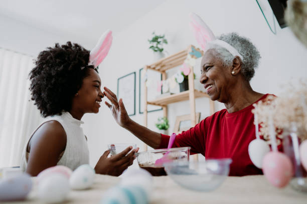 großmutter und enkelin bereiten schokolade für ostern vor - easter easter egg child chocolate stock-fotos und bilder