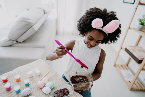 Child girl preparing chocolate for easter