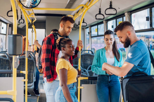 istock Young multiracial friends talking while riding a bus in the city 1473315309