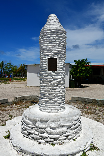 Nibok, Nibok District, Nauru: Column marking the origins of the Nauru Congregational Church - the 1887 landing of Timoteo Tabwia, its pioneer missionary and a Gilbert Islander. Congregationalism is a Protestant movement within the Calvinist tradition that occupies a theological position between Presbyterianism on one end and the Baptists and Quakers on the other. The Nauru Congregational Church (NCC) is the largest religious denomination in Nauru, claiming as members approximately 60% of the population.