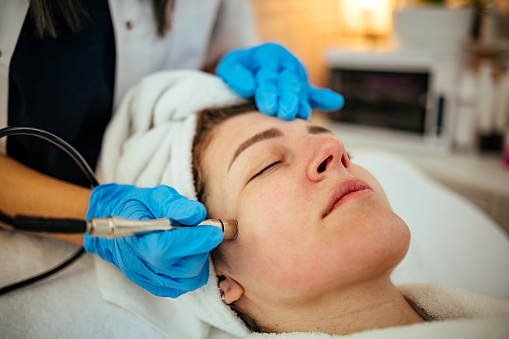 Beautician makes Ultrasonic cleaning of the face in spa salon. cosmetology