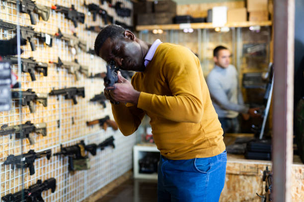 istock African-american man selecting gun in weapon shop 1473320008