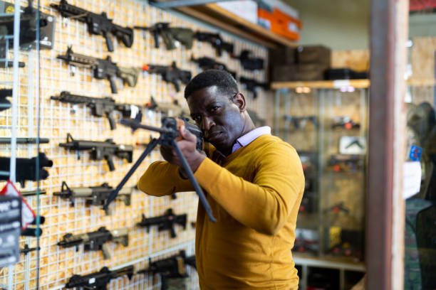 istock African-american man selecting gun in weapon shop 1473320847