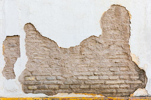 Background texture of an old bricked house wall with cracked paint