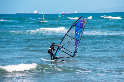 Enjoying extreme windsurfing and ocean waves on the hot sunny day