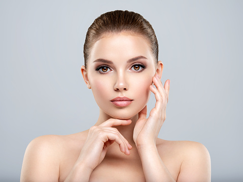 Front portrait of a white young woman with beauty face - isolated. Skin care concept. Young adult  caucasian girl with a clean skin.