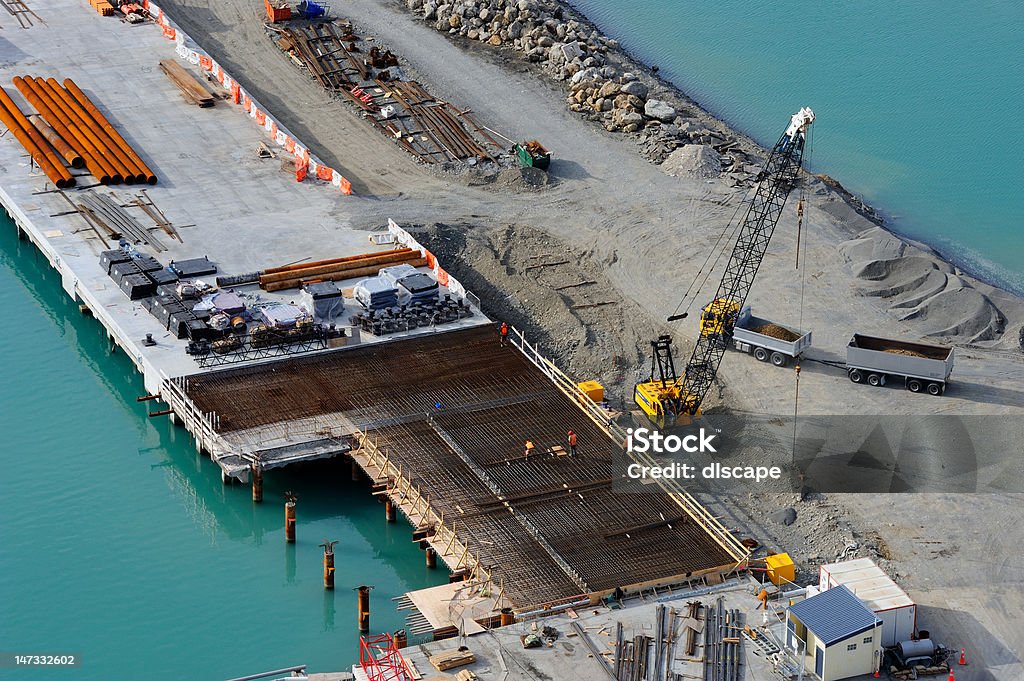 Dockside construction site A large crane gets ready to lift more re-bar into some foundations which are being build on in the Napier port, New Zealand. Construction Site Stock Photo