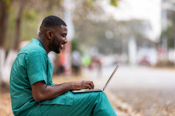 istock Young African Businessman with a laptop outdoors talks to clients remotely. 1473328823