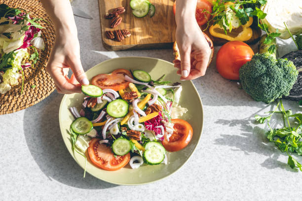 istock A woman makes a fresh vegetable salad, close-up. 1473332009