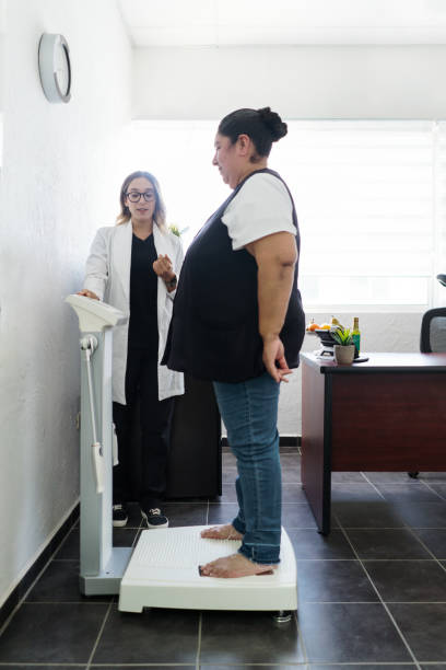 Overweight woman standing on inbody scale stock photo