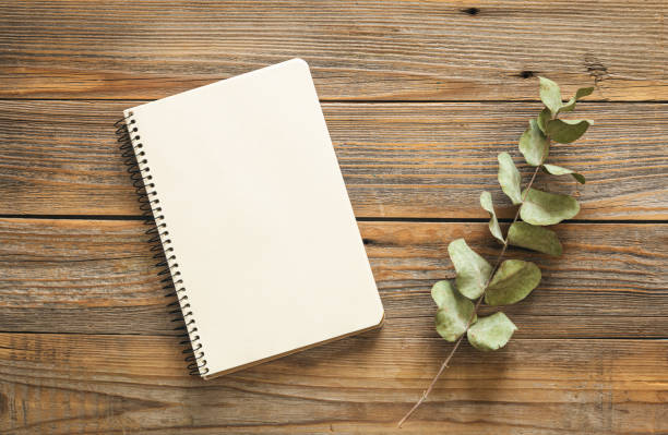 istock Notepad and eucalyptus branch on a wooden background. 1473335378