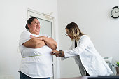 Nutritionist measuring overweight woman's waist