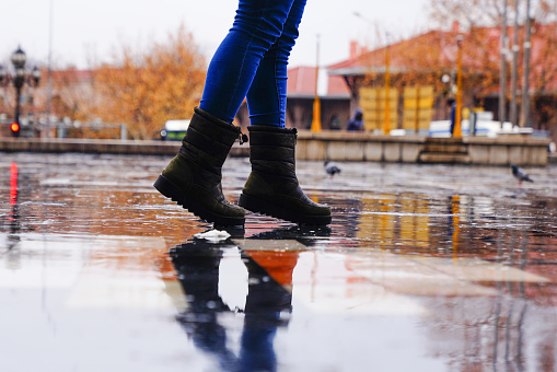Close up of women's shoes walking during rainy day in the city
