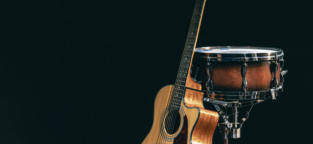 istock Acoustic guitar and snare drum on a black background isolated. 1473337499