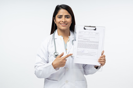 Diagnosis concept. Young cheerful doctor showing on folder