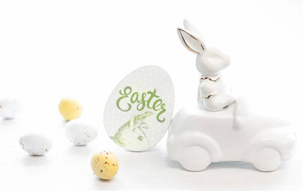istock Easter background with a ceramic hare in the car and eggs on a white background, 1473338196