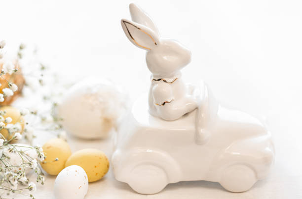 istock Easter background with a ceramic hare in the car and eggs on a white background, 1473338207