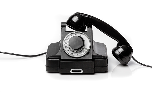 Vintage black telephone  on a white bachground. Telecom technology conept