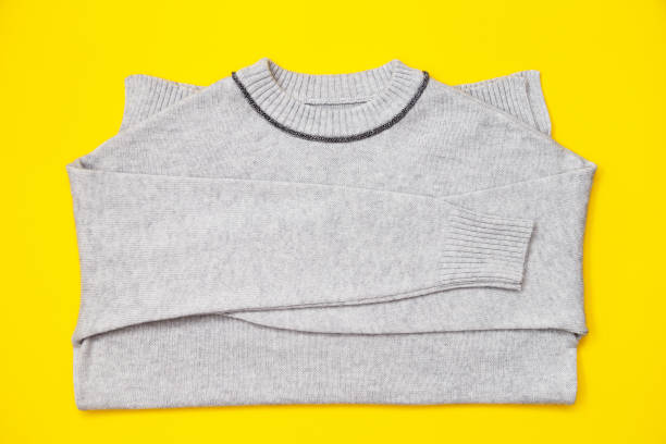 istock Knitted pullover in trendy grey color on yellow background, flay lay. 1473339801