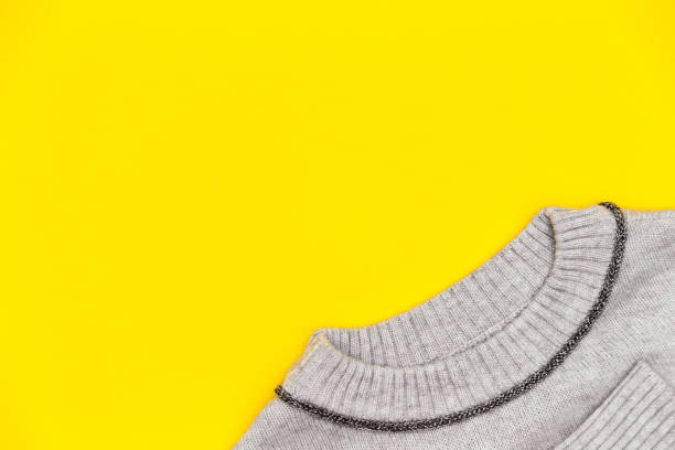 istock Knitted pullover in trendy grey color on yellow background, flay lay. 1473339817