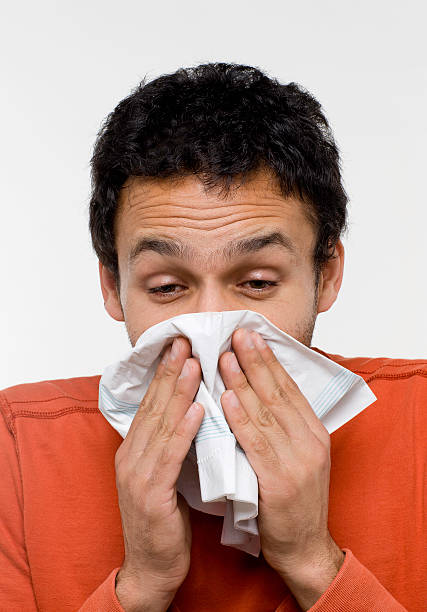 istock Sick man about to sneeze into a tissue 147334262