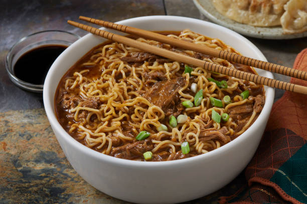 Birra Ramen with Braised Beef Birra Ramen with Braised Beef and Pan Fried Dumplings madeira sauce stock pictures, royalty-free photos & images