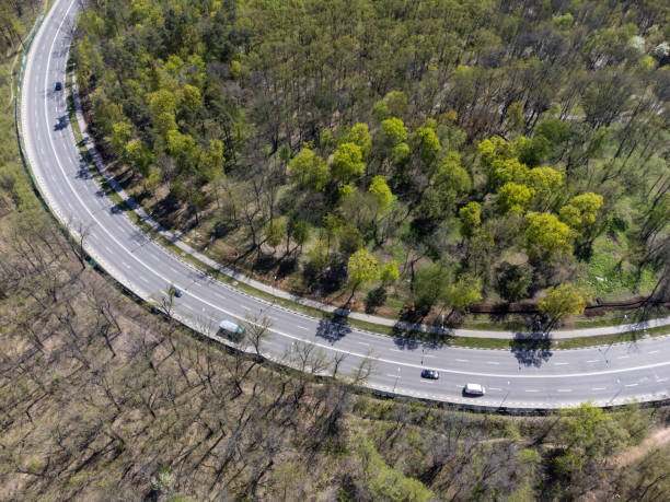 istock Aerial look down spring road curve in greenery 1473346627