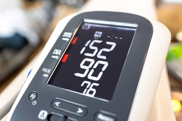 不健康なライフスタイルと高血圧の可能性を表す、高い拡張期および収縮期の数を示すデジタル家庭用血圧計の接写。