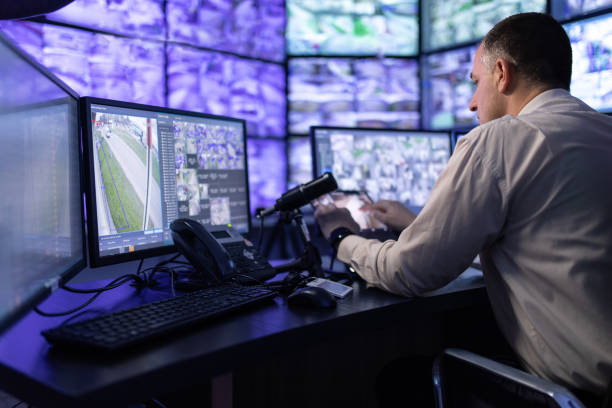 istock Man working in surveillance room and looking at monitors 1473350417
