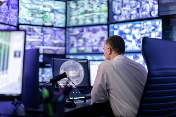istock Man working in surveillance room and looking at monitors 1473350427
