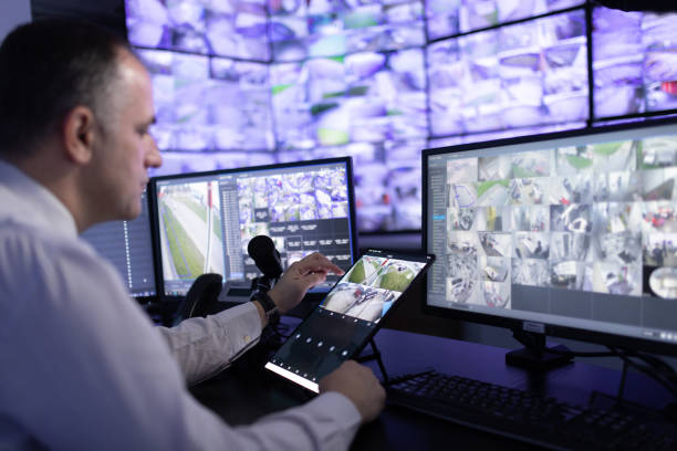 istock Man working in surveillance room and looking at monitors 1473350428