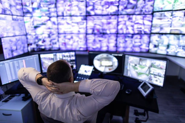 istock Man working in surveillance room and looking at monitors 1473350465