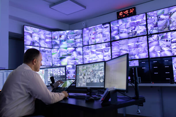 istock Man working in surveillance room and looking at monitors 1473350469