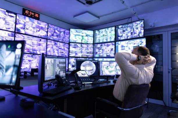 istock Man working in surveillance room and looking at monitors 1473350479