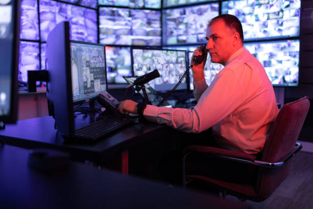 istock Man working in surveillance room and looking at monitors 1473350480