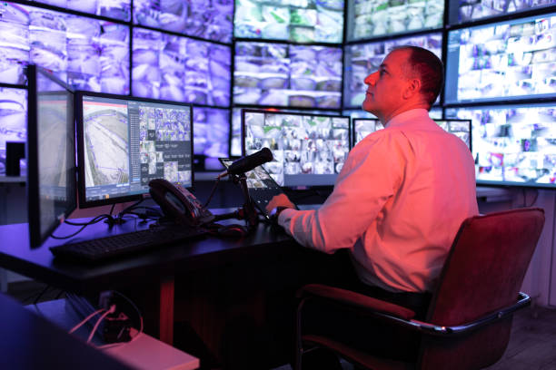 istock Man working in surveillance room and looking at monitors 1473350502