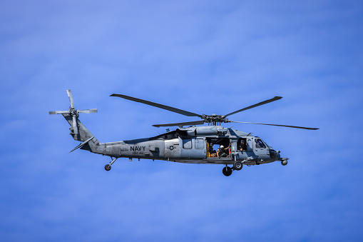 Norfolk, Virginia, USA - February 7, 2023: Navy helicopter with a patient and doors fully open getting ready to land on the Norfolk hospital helipad.