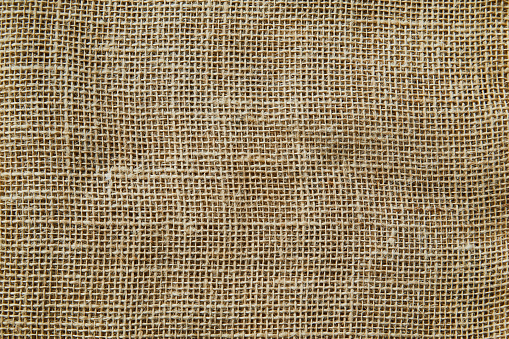 A beautiful light burlap natural texture background, with shades and shadows, background ideal for product placement, with a large copy space area