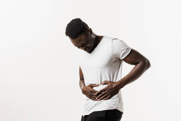 Sick african american man is holding his stomach because it hurts. Pancreatitis disease of pancreas becomes inflamed. Cancer of stomach and esophagus of African man. Sick african american man is holding his stomach because it hurts. Pancreatitis disease of pancreas becomes inflamed. Cancer of stomach and esophagus of African man endometriosis bloated stock pictures, royalty-free photos & images