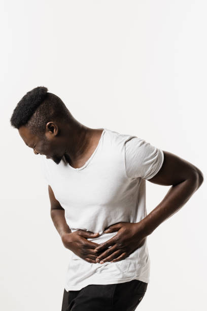 Sick african american man is holding his stomach because it hurts. Pancreatitis disease of pancreas becomes inflamed. Cancer of stomach and esophagus of African man. Sick african american man is holding his stomach because it hurts. Pancreatitis disease of pancreas becomes inflamed. Cancer of stomach and esophagus of African man endometriosis bloated stock pictures, royalty-free photos & images