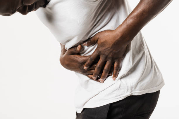 Appendicitis is inflammation of appendix. African american man feel abdominal pain, fever, vomiting, and loss of appetite because of appendicitis inflammation. Appendicitis is inflammation of appendix. African american man feel abdominal pain, fever, vomiting, and loss of appetite because of appendicitis inflammation endometriosis bloated stock pictures, royalty-free photos & images
