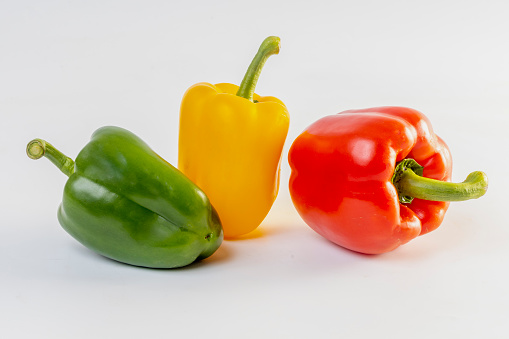 Fresh red, orange and yellow Bell peppers isolated on white. Image includes a clipping path.
