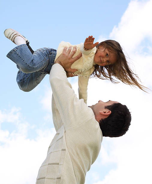 Father lifting little daughter stock photo
