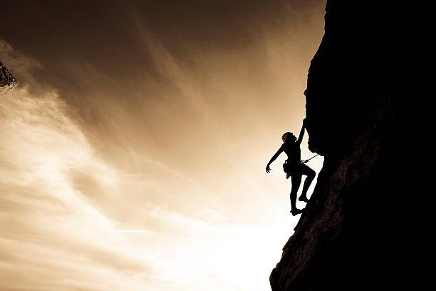 istock Silhouette of a rock climber clinging to a cliff 147336623