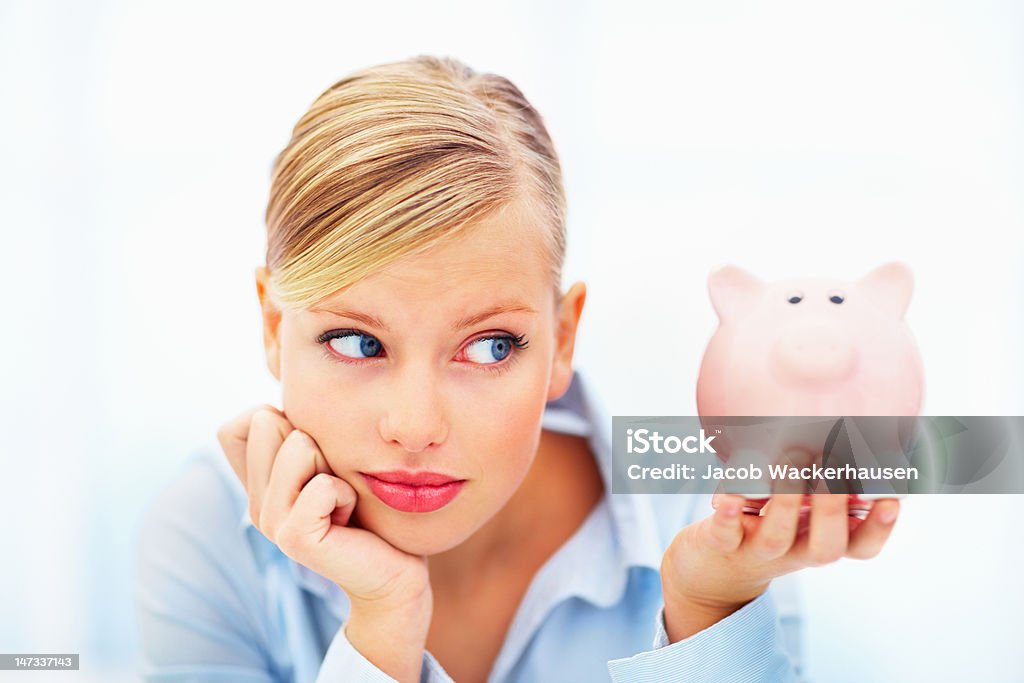 Close-up de uma jovem mulher segurando um piggy bank - Foto de stock de Cofre de porquinho royalty-free