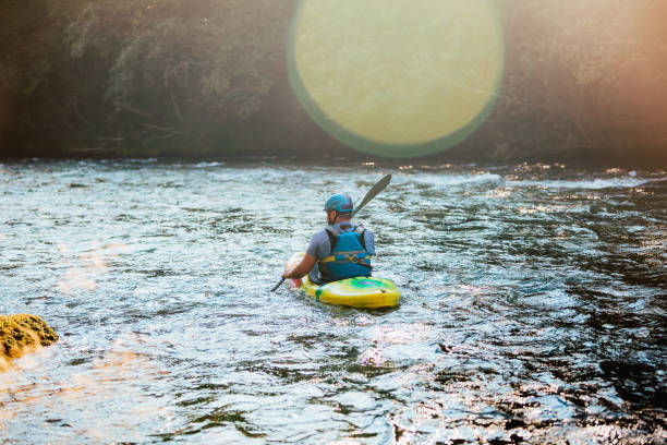 istock Man kayaking upstream, paddling on the turbulent river 1473373432