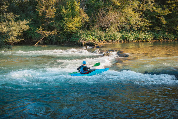 istock Man kayaking upstream, paddling on the turbulent river 1473373471