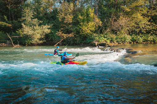Whitewater kayaker paddling on the waters of river. Adrenaline seekers and nature lovers.